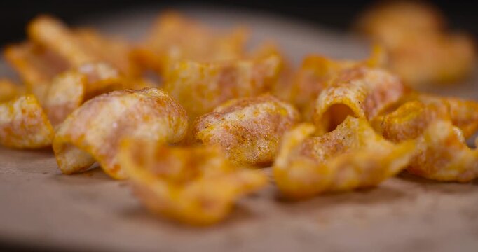 crispy mashed potato chips fried in a large amount of sunflower oil, sprinkled with red hot pepper spices, crispy delicious chips with spices are scattered on the table