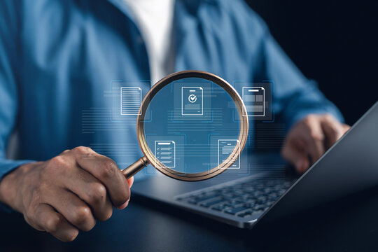 Document quality inspecting and compliance verification process with magnifying glass. close up of a man checking a paper document for accuracy and standards.