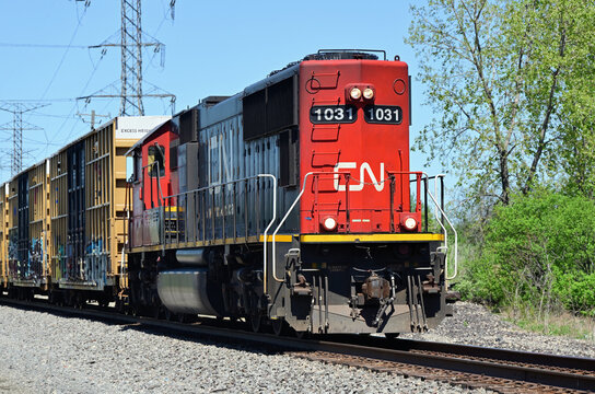 Running long-hood forward, a single Canadian National Railway locomotive leads a short local freight train southbound through an area in southwest suburban Chicago.