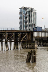 Fototapeta premium Modern Riverside Condominium Tower by a Timber Pier in New Westminster, Vancouver, BC, Canada