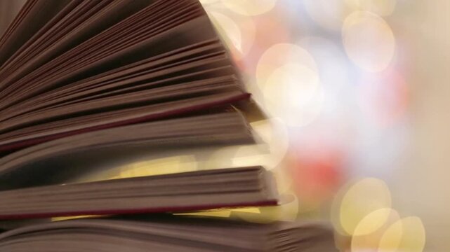 Book pages close-up with Warm Festive Lights in Soft Focus for Christmas reading themes,education projects,winter study campaigns,literary blogs, bookstore promotions,cozy lifestyle.4k footage