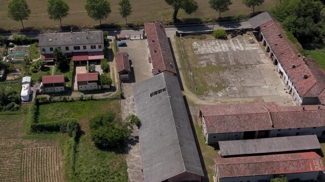 Aerial View of Agricultural Farmstead: An expansive aerial perspective showcases a sprawling farm complex, complete with residential buildings, barns, and agricultural fields.