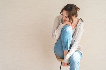 Fototapeta premium ハイチェア,椅子に座るデニム姿の女性モデル