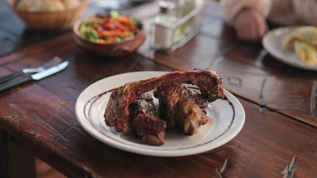 Traditional Argentine grilled goat meat close-up on rustic table.