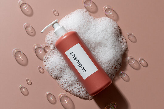 Top Down View Of Shampoo Bottle With Foam And Bubbles On Pink Background