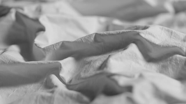 Close-up of wrinkled white linen fabric or bed sheets.