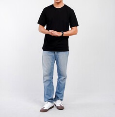 Obraz premium Male body wearing black t-shirt and blue jeans seen from behind and isolated on white background