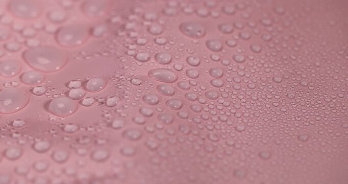 wet pink smooth plastic for wrapping gifts and bouquets, covered with water droplets smooth pink synthetic material, rainy day