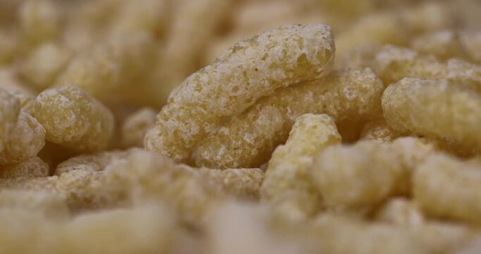 yellow large sweet sticks of corn flour with added sugar for quick cooking with milk or yogurt, ready-to-eat sticks scattered on food paper