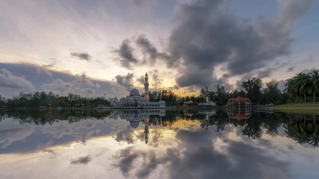 Beautiful Sunset Time Lapse of Tengku Tengah Zaharah Floating Mosque in Terengganu Malaysia, Scenic Reflection on Lake Water with Dramatic Clouds in Evening Dusk Sky. Zoom In motion timelapse.