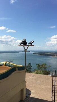Scenic viewpoint from Buddhist temple terrace overlooking river and town with naga serpent railing