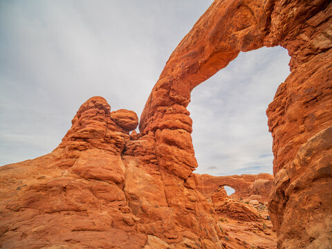 The elegant Corona Arch spans red sandstone in the desert.