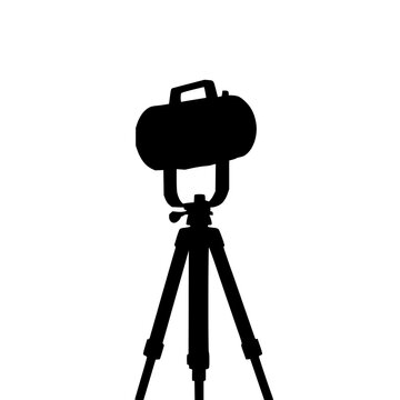Vintage theatrical spotlight set with solid black silhouette on tripod, film noir aesthetic featuring spotlight, silhouette, tripod with film studio and stage lighting