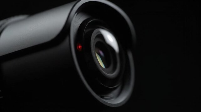 Close up of security camera lens rotating with active red light