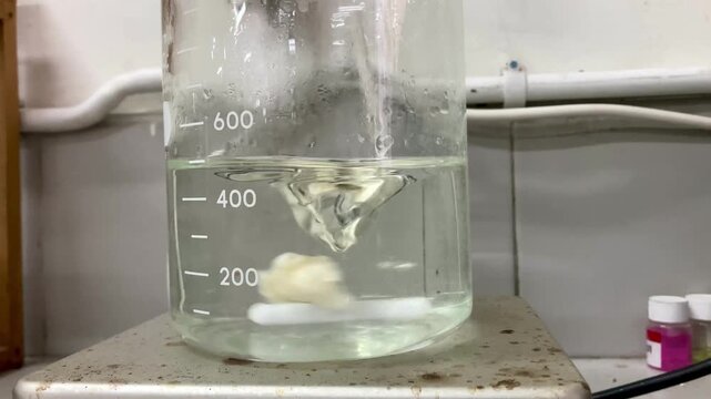 liquid stirring in a glass beaker on a magnetic stirrer hotplate in a laboratory