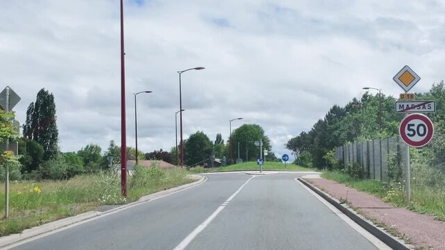Vehicle Driving Toward a Roundabout on a French Road in Paris