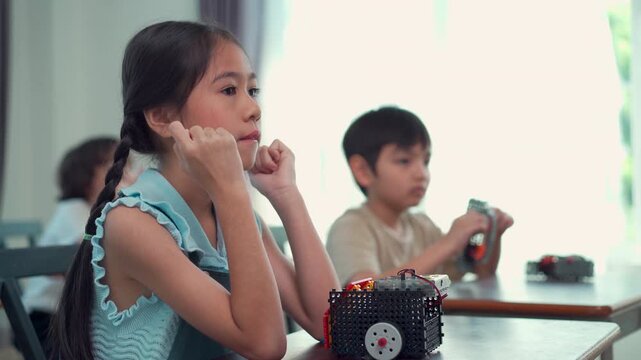 Happy school children participating in interactive STEM lesson