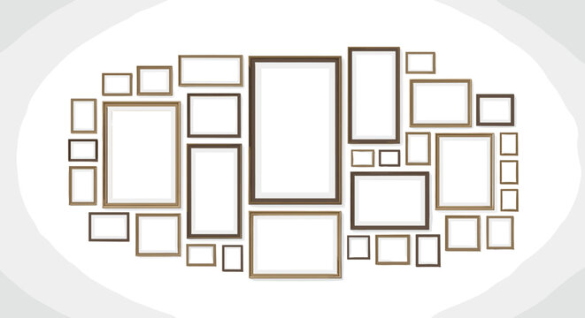 Arrangement of various sized empty picture frames in wooden tones mounted on a light gray wall creating a gallery wall layout.