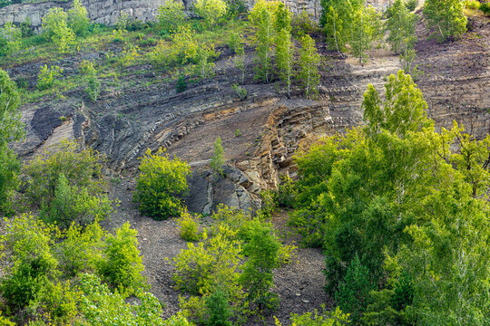 Complex folded sedimentary strata with anticline-syncline structures and talus deposits on Lower Carboniferous limestone outcrop
