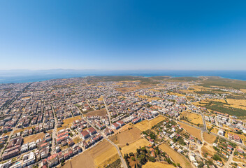Fototapeta premium Didim, Turkey. Top down view showing geometric patterns of farmland, town streets and coastal mountains. Aerial view