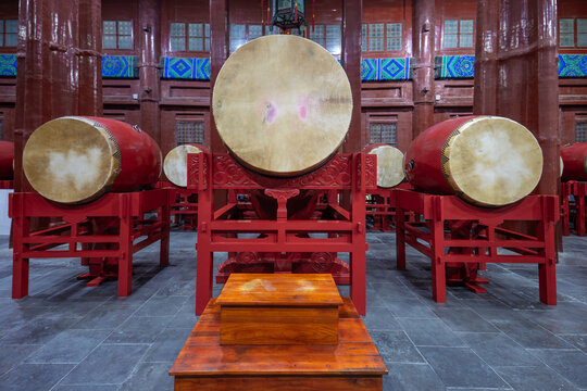 A traditional Chinese red drum array inside the Drum Tower in Beijing, China, showcasing classical architecture and intangible cultural heritage percussion instruments.