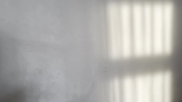 Still footage of a grunge cracked wall with soft window light reflections. Ideal for cinematic overlays, editorial backdrops, luxury branding, and ambient visuals.