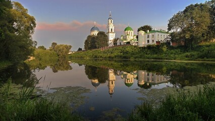 Obraz premium Monastery on the River Bank at Sunset