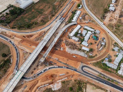 The construction site before the construction of the concrete bridge over the intersection by crane workers, tractors, and backhoes