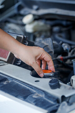 Close up of a hand of woman is checking a liquid coolant pot