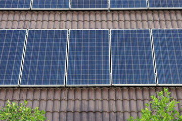 Fototapeta premium Solar panels installed on a brown tiled house roof