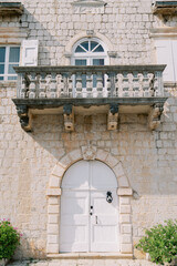 Decorative stone exterior with balcony. Charming limestone structure featuring arched entrance © VolodymyrNadtochii