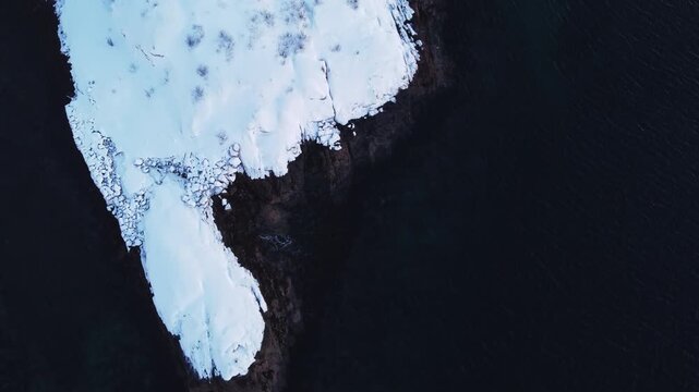 High angle drone shot of drifting ice and frozen coastline in arctic Norway. Abstract winter texture of the icy ocean waters near the Lofoten Islands during the winter season