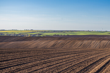 Farm Fields Ready for Planting in the Countryside During Spring With Clear Skies and Distant Hills Visible © Роман Булатов