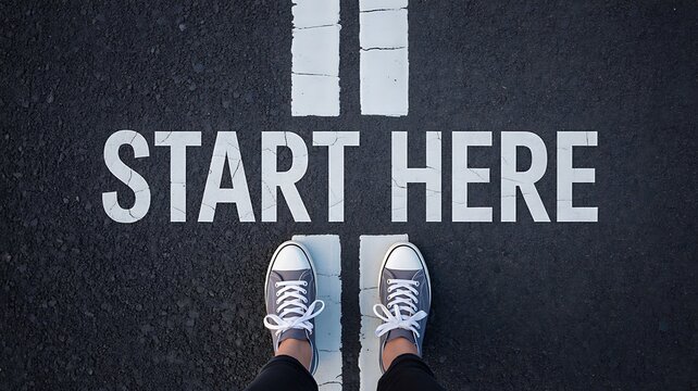 Motivational start here message with shoes on road for new beginning concept