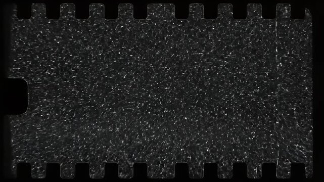 A close-up view of a film strip reveals a grainy, textured surface with perforations along the edges, evoking a sense of vintage photography and cinematic history.