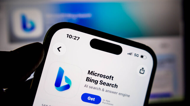 Closeup of a hand holding a smartphone displaying the microsoft bing search app page on the apple app store