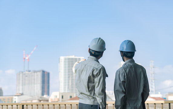 建設中の都市を眺める男性作業員のグループ