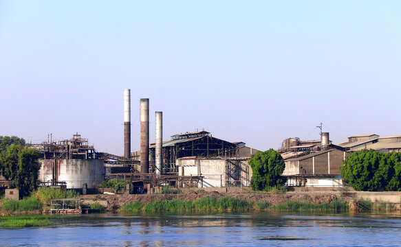 Abandoned industrial zone on the banks of the Nile River, Egypt. Old derelict factory with smokestacks and decaying buildings. Industrial decay concept