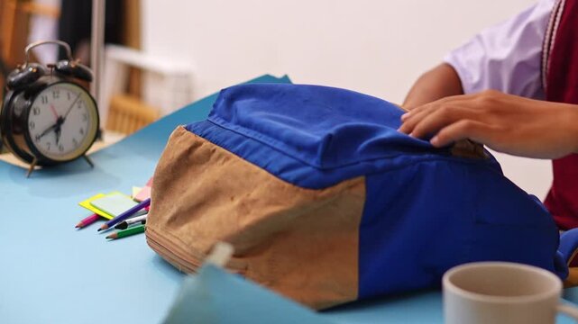 Close-up of hands Student clearing blue backpack to make room for note-taking and creative planning