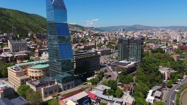 aerial of central Tbilisi, Georgia the Kura River lush riverbank parks, and the modern Biltmore Hotel skyscraper on the on the skyline