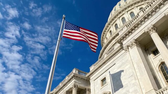 American flag waving on pole at United States Capitol building in Washington DC