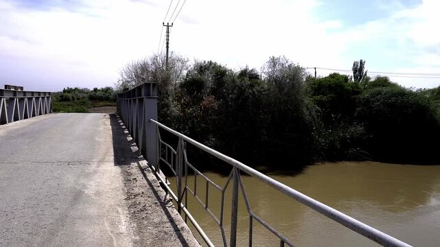 4K view of a small concrete highway bridge over a wide water canal