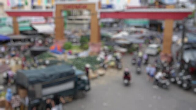 Bokeh view of Traditional Vietnamese Tet holiday shopping scene. Cho Dam market with crowded street stalls and motorbikes before Lunar New Year celebration in Vietnam. Blurred background footage.