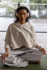 Fototapeta premium Nonbinary person meditating on wet deck, smartwatch activating animated heart rate rings for health