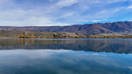 Obraz premium Scenic Landscape of Lake Dunstan with Calm Water and Mountain Range
