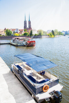 Poland, Wroclaw, 10.05.2026. Scenic view of motorboats and a paddle steamer docked near Ostrow Tumski on the Oder river in Wroclaw, Lower Silesia, Poland on a bright sunny day