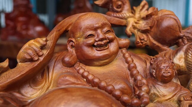 Wooden statue of Laughing Buddha or Maitreya for luck and prosperity. Close-up of traditional Vietnamese carved feng shui deity figurine before Lunar New Year celebration.