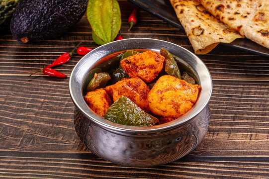 Indian Paneer Tikka Masala inl with Roti bread on a dark wooden table