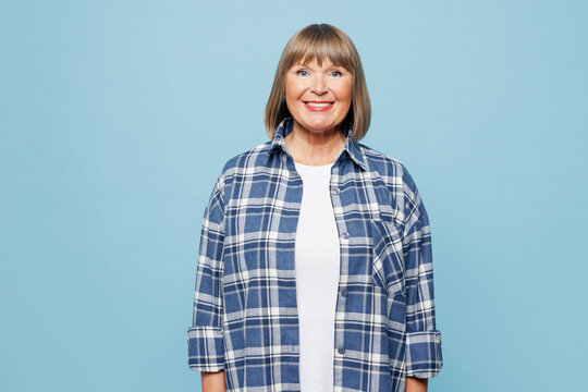 Elderly smiling happy cheerful satisfied blonde woman 50s years old wear checkered shirt casual clothes looking camera isolated on plain pastel light blue background studio portrait Lifestyle concept