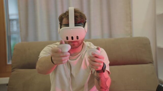 Caucasian man with a vr headset playing an interactive video game using controllers at home like a shooting game